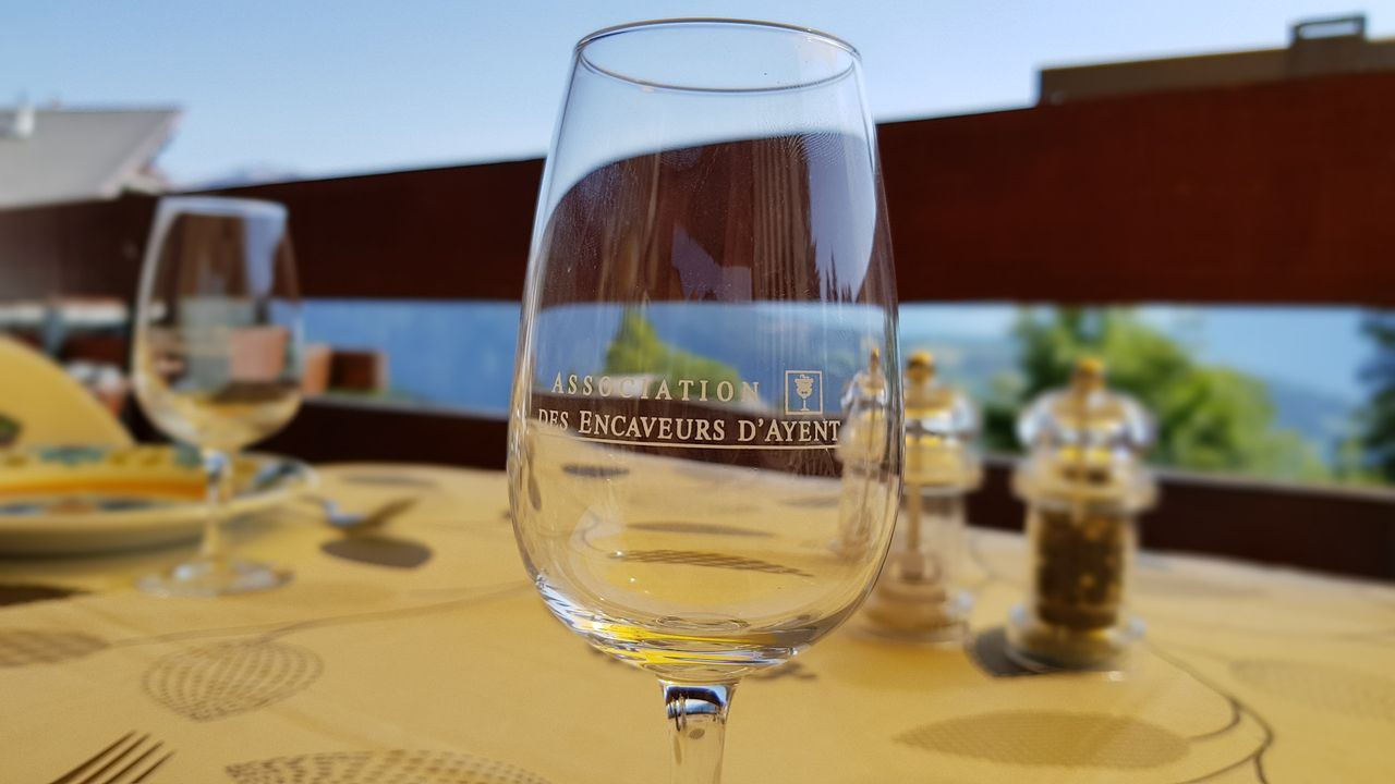 Verre de l'Association des encaveurs d'Ayent sur la table de la terrasse